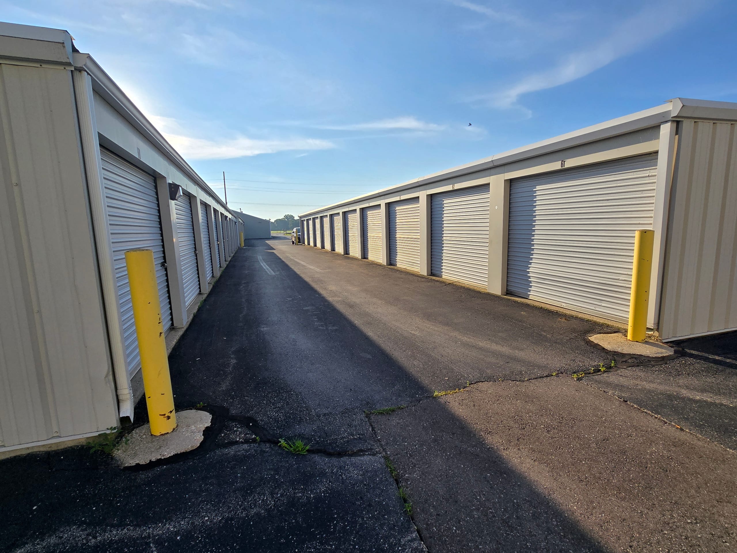 Wide paved driveway between two rows of storage units at Evergreen Mini Storages